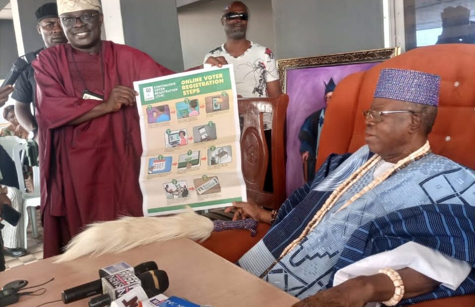 Oyo State INEC REC, Mr Mutiu Agboke presenting the Olubadan with the “Online Voter Registration Steps” poster